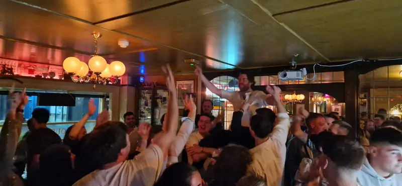 Arms up in a packed pub